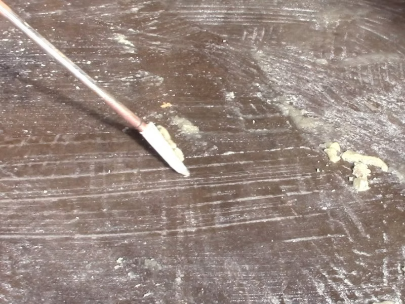 Sealer stripper being applied to a brown concrete floor